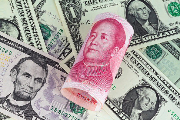 Chinese Yuan Renminbi with portrait of Mao Zedong and Dollar banknotes with portraits of Benjamin Franklin and George Washington